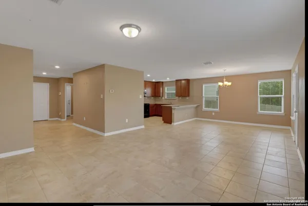 a view of empty room with a kitchen