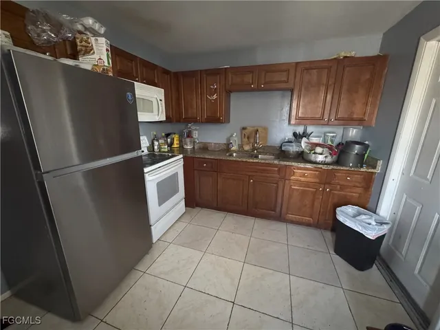 a kitchen with stainless steel appliances granite countertop a refrigerator and a sink
