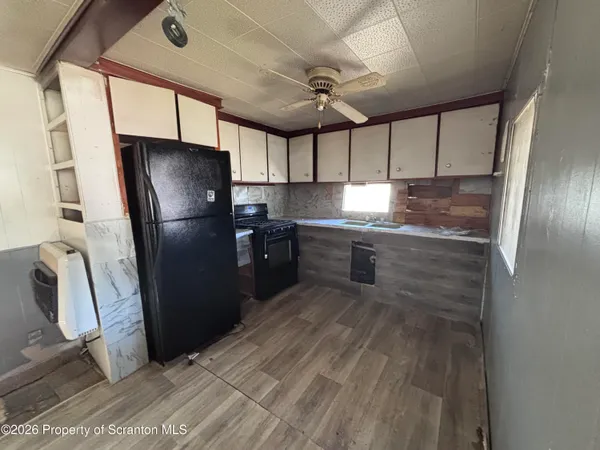 a kitchen with granite countertop a refrigerator and a sink