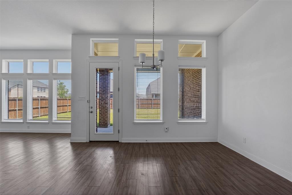 845 Ranchland Road Justin, TX 76247 - Photo 14 of 22 an empty room with wooden floor and windows