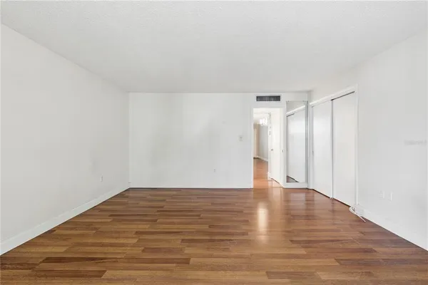 a view of an empty room with wooden floor