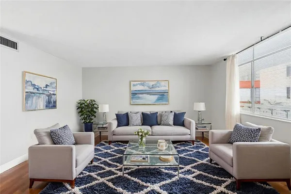 a living room with furniture a rug and a large window