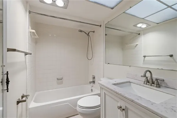 a bathroom with a granite countertop sink toilet and shower