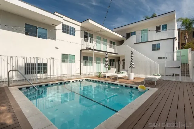 a view of a white house with a swimming pool