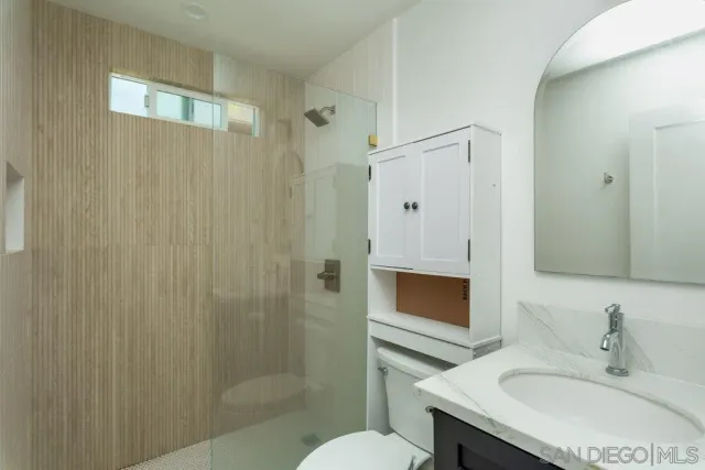 a bathroom with a sink toilet a mirror and shower