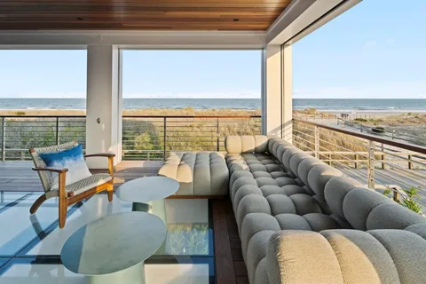 a living room with furniture and floor to ceiling windows