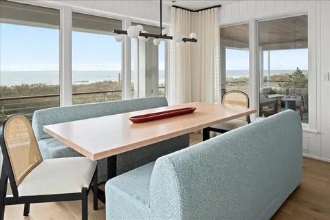 a view of a dining room with furniture large windows and wooden floor