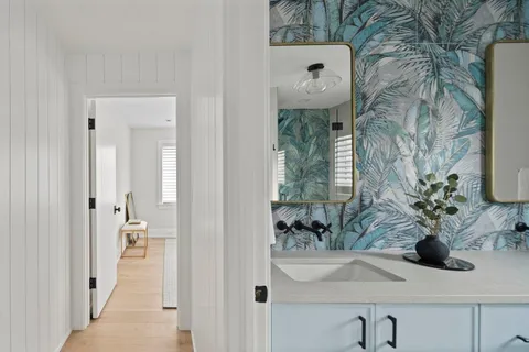 a bathroom with a sink and mirror with bathtub