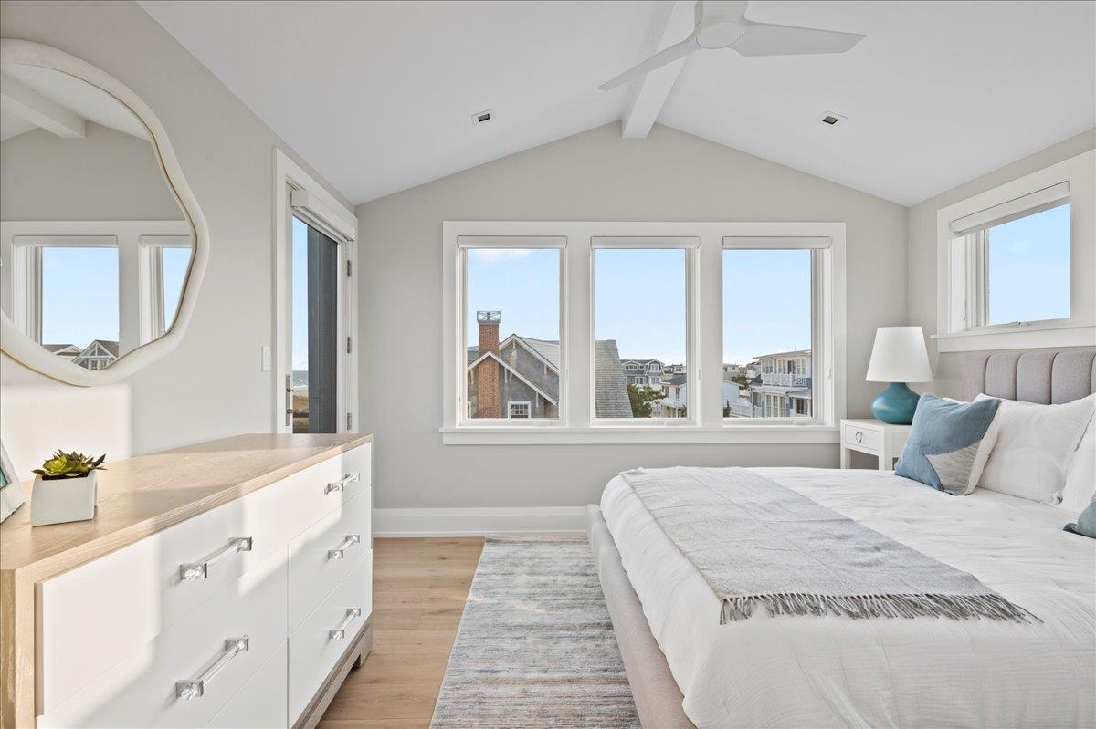 83 25th Street East Avalon, NJ 08202 - Photo 30 of 47 a spacious bedroom with a large bed and a chandelier