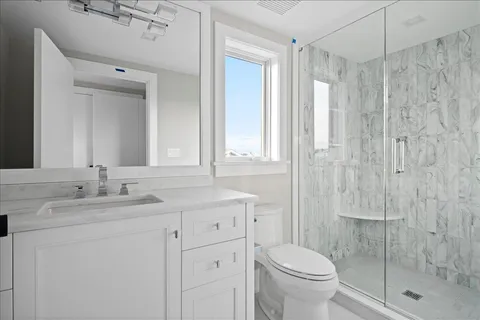 a bathroom with a granite countertop sink toilet and shower