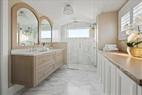 a spacious bathroom with a granite countertop sink a mirror and shower