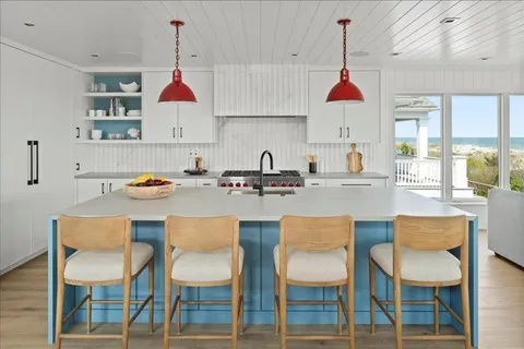 a kitchen with a dining table chairs and white cabinets
