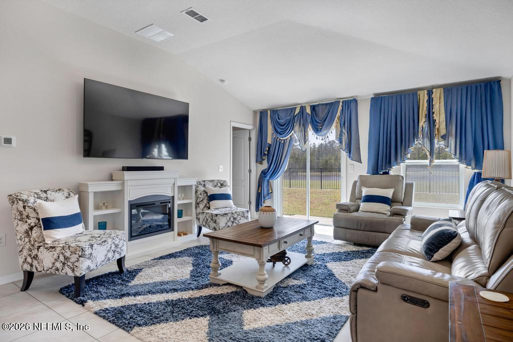 86178 Mainline Road Yulee, FL 32097 - Photo 14 of 61 a living room with furniture fireplace and a flat screen tv