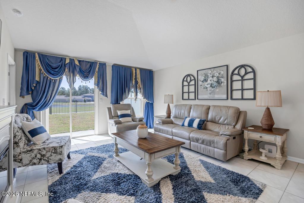86178 Mainline Road Yulee, FL 32097 - Photo 16 of 61 a living room with furniture a rug and a large window