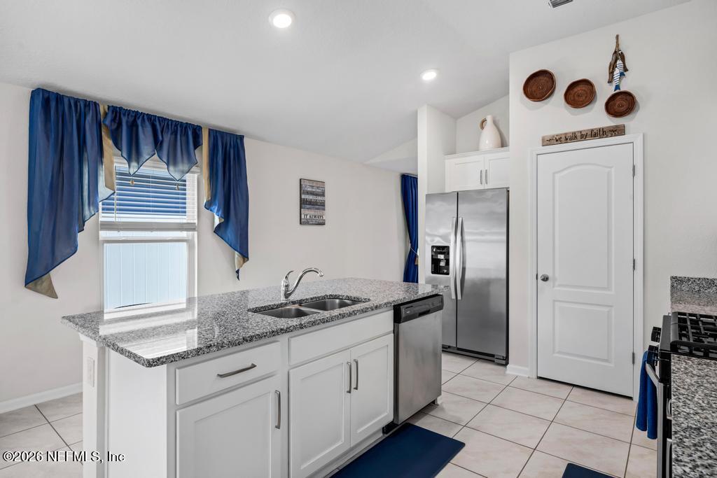 86178 Mainline Road Yulee, FL 32097 - Photo 22 of 61 a kitchen with stainless steel appliances granite countertop a sink a stove a refrigerator and cabinets