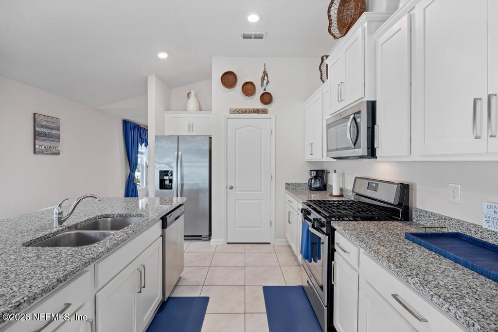 86178 Mainline Road Yulee, FL 32097 - Photo 23 of 61 a kitchen with stainless steel appliances granite countertop a sink stove and refrigerator