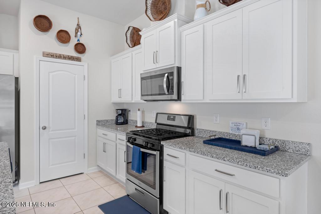 86178 Mainline Road Yulee, FL 32097 - Photo 24 of 61 a kitchen with stainless steel appliances granite countertop a sink a stove and cabinets