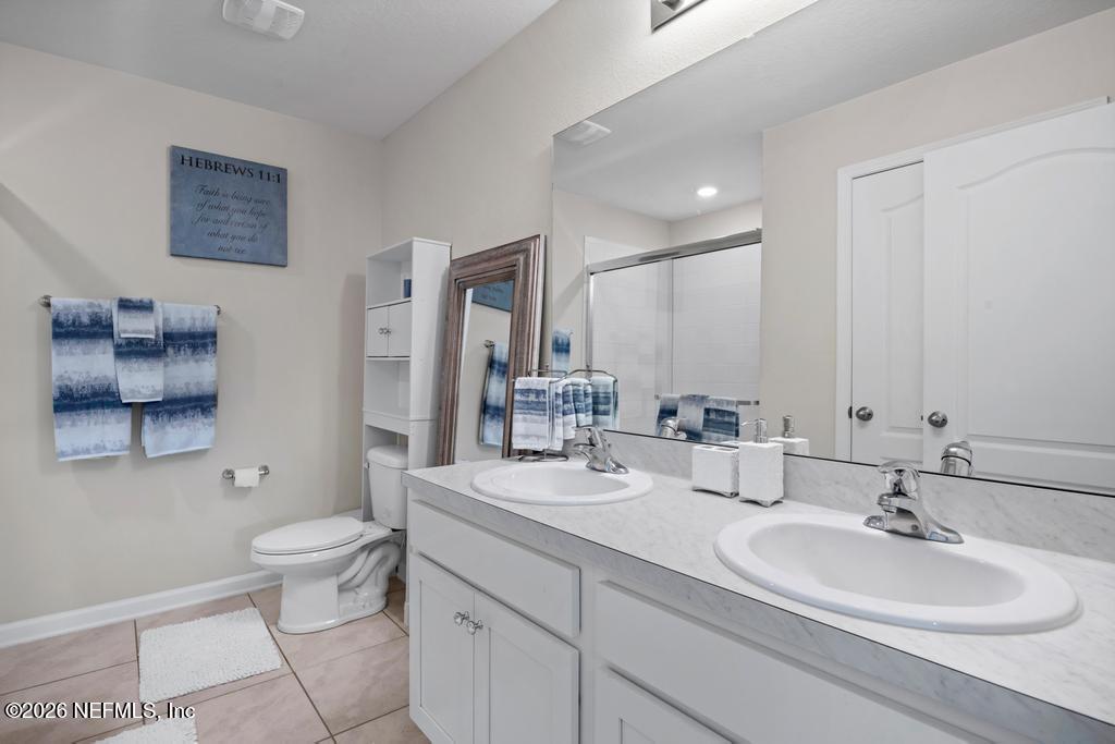 86178 Mainline Road Yulee, FL 32097 - Photo 28 of 61 a bathroom with a double vanity sink toilet and a mirror