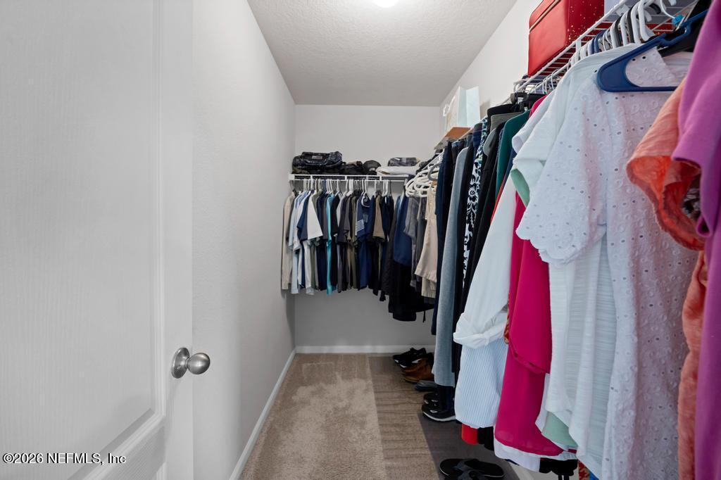 86178 Mainline Road Yulee, FL 32097 - Photo 30 of 61 a view of walk in closet with clothes and shoes