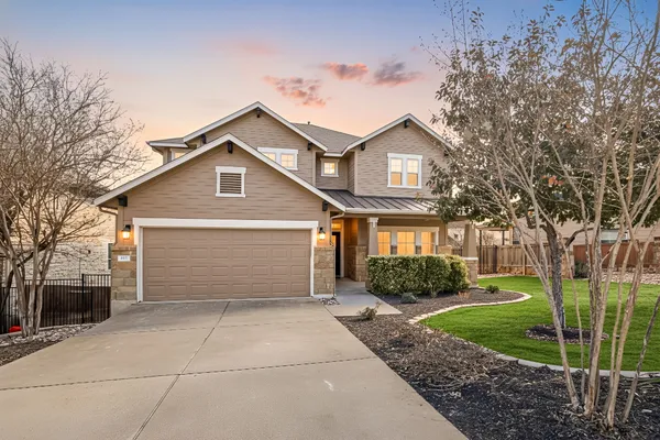 a front view of a house with a garden and garage