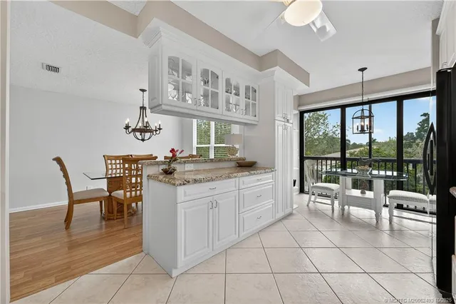 a kitchen with stainless steel appliances kitchen island granite countertop a table and chairs in it