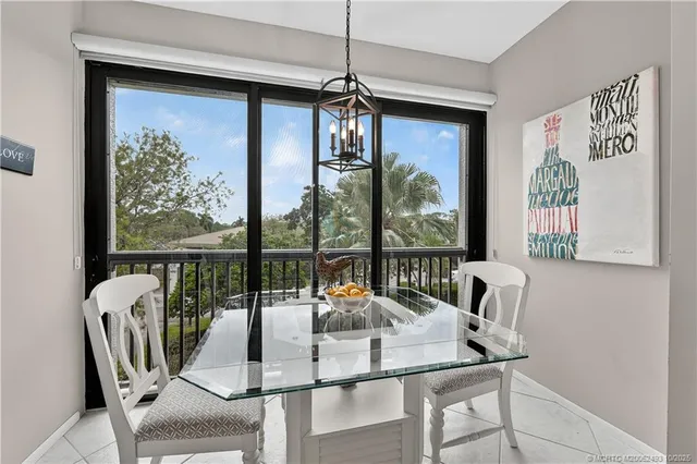 a dining room with furniture a chandelier and glass door
