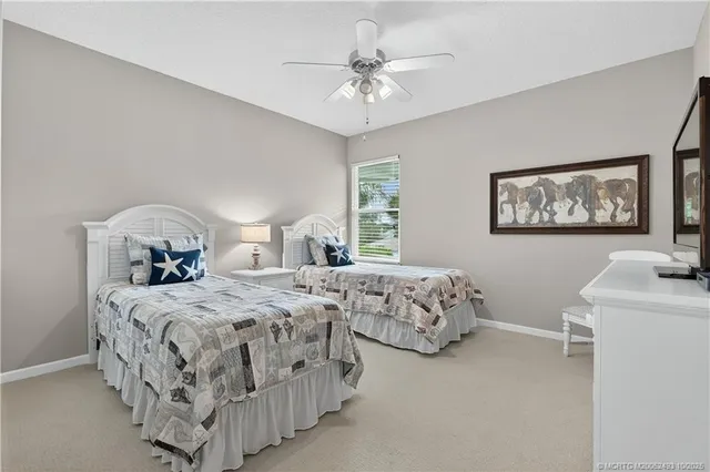 a bedroom with two beds and a chandelier