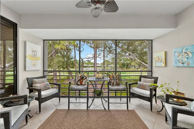 a living room with furniture and a floor to ceiling window