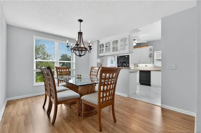 a dining room with furniture a chandelier and wooden floor
