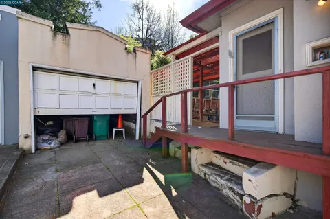 a view of a backyard with wooden fence and a large tree