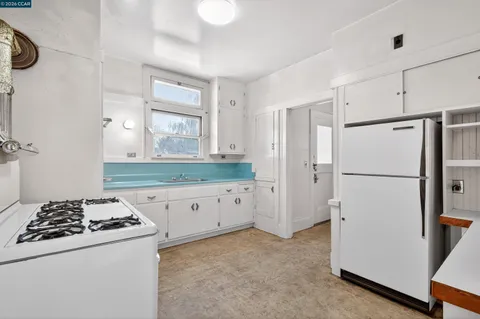 a kitchen with white cabinets and white appliances