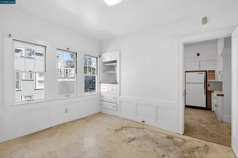an empty room with windows and cabinet