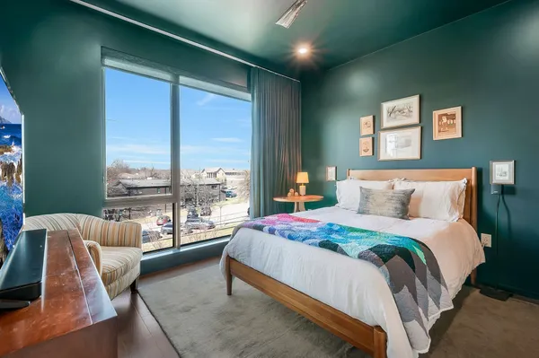 a bedroom with a bed and glass walk in closet