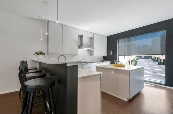 a kitchen with stainless steel appliances a table and chairs in it