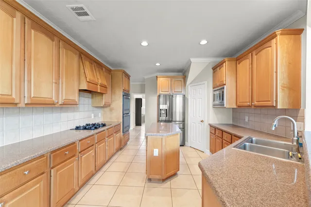 a large kitchen with stainless steel appliances granite countertop a sink and cabinets