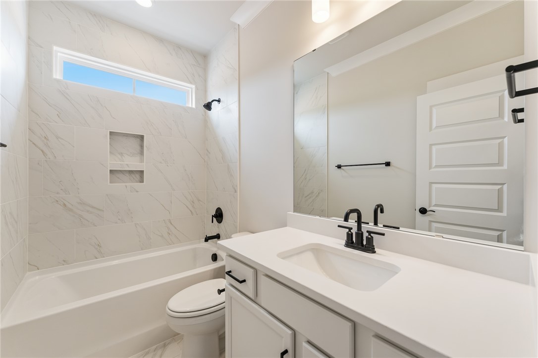 310 Bluestem Court Anderson, SC 29621 - Photo 7 of 36 This bright bathroom features sleek tile, a modern vanity, and a refreshing tub.
