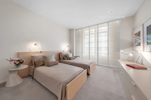 a spacious bedroom with a bed and a lamp