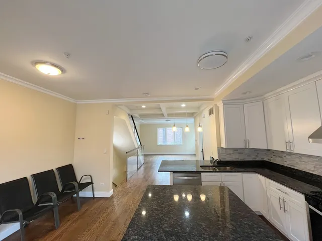 a view of an empty room with wooden floor and windows