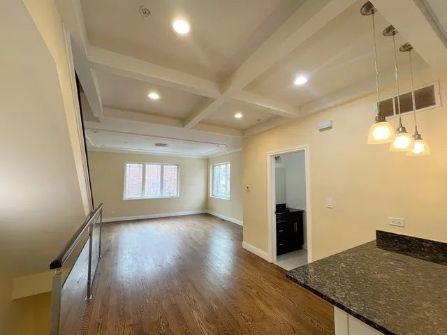 a kitchen with granite countertop a stove a sink and a refrigerator