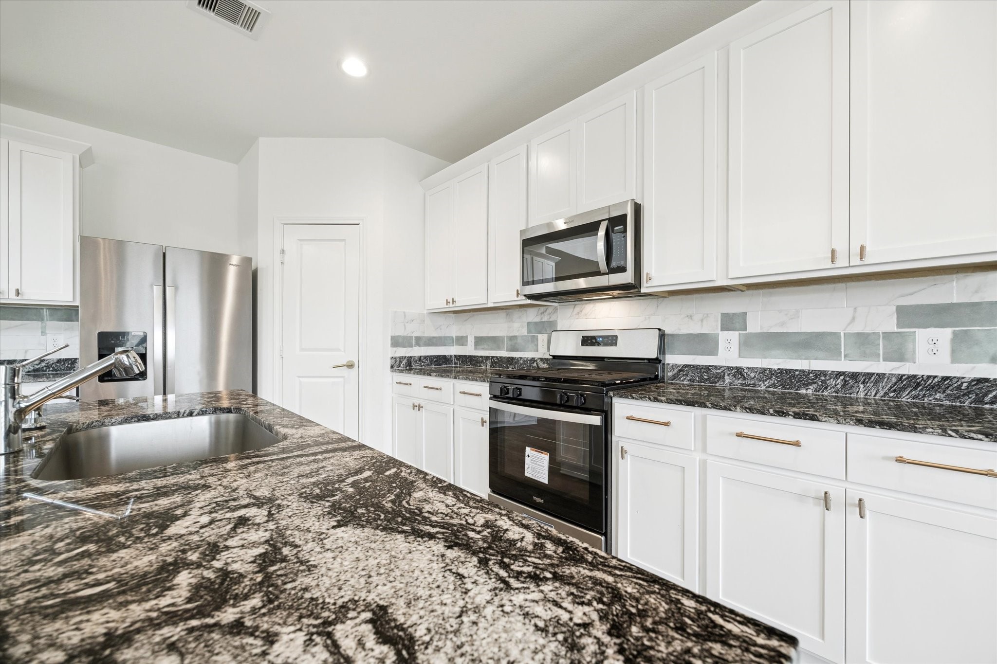 2938 Bur Landing Lane Rosenberg, TX 77469 - Photo 11 of 21 a kitchen with granite countertop a stove sink and microwave