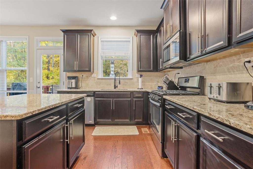 821 Tramore Court Acworth, GA 30102 - Photo 19 of 63 a kitchen with stainless steel appliances granite countertop hardwood floor sink stove and granite counter top