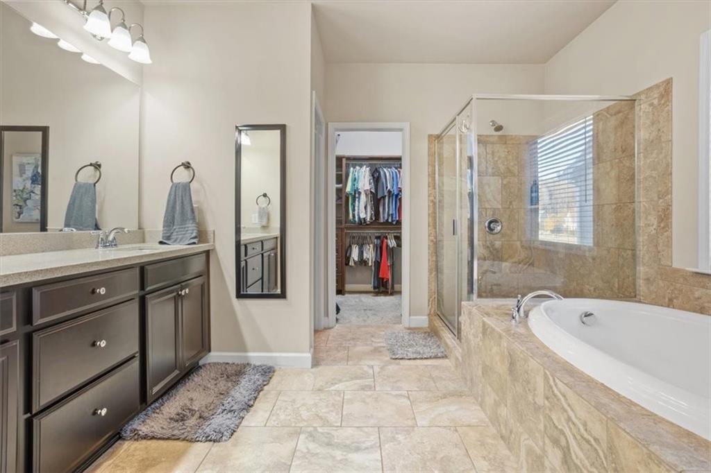 821 Tramore Court Acworth, GA 30102 - Photo 31 of 63 a spacious bathroom with a tub sink and mirror