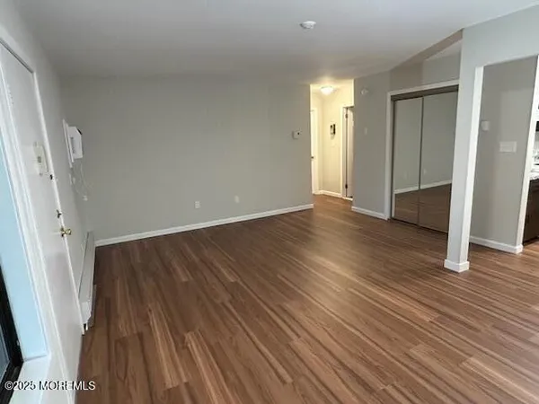 an empty room with wooden floor and a window