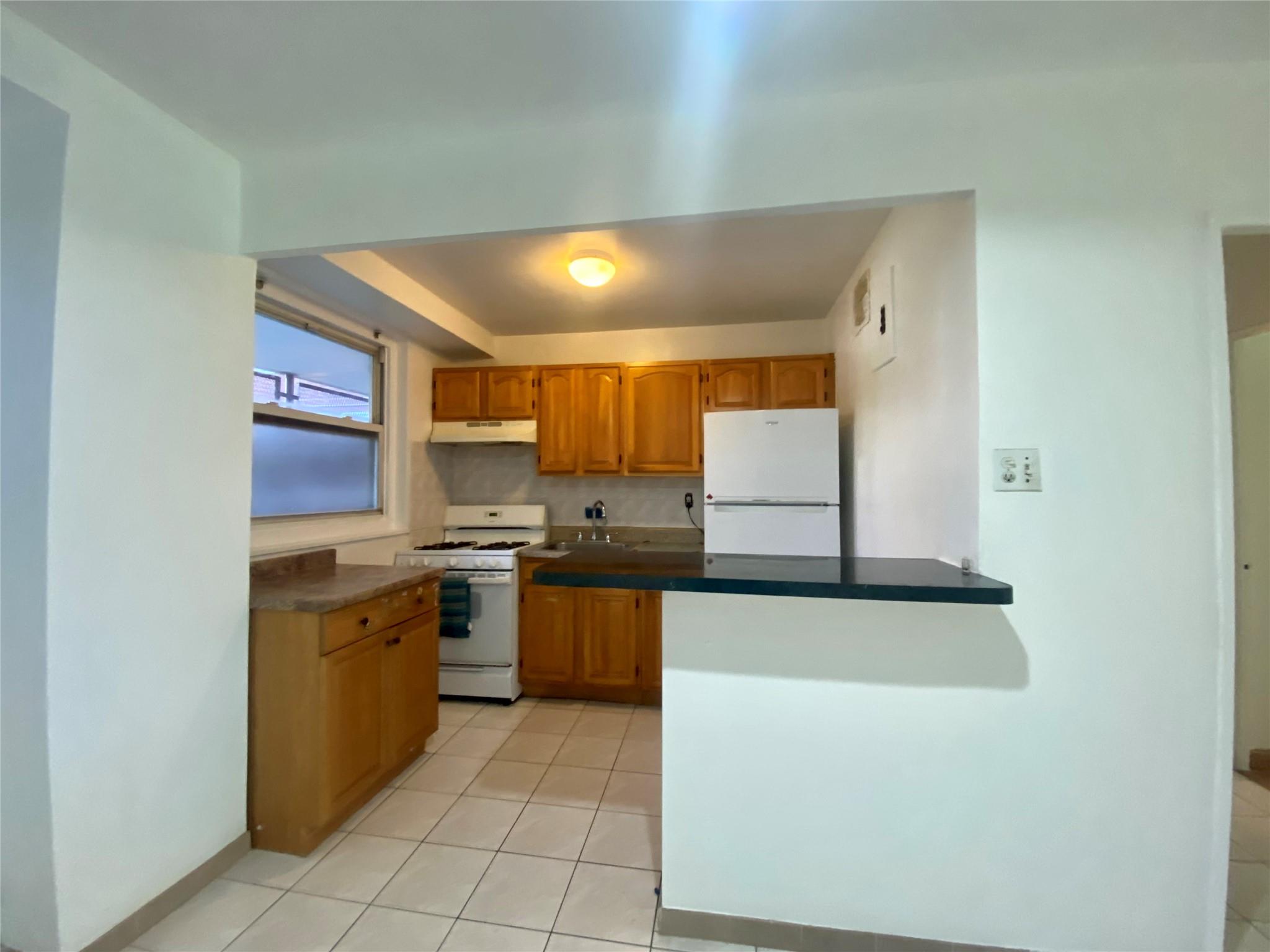 98-05 63rd Road, Unit 1C Queens, NY 11374 - Photo 8 of 11 a kitchen with stainless steel appliances granite countertop a stove and a sink