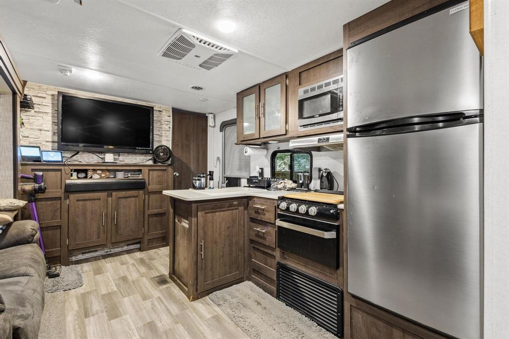 988 County Road Gordonville, TX 76245 - Photo 15 of 35 a kitchen with a refrigerator and a stove top oven