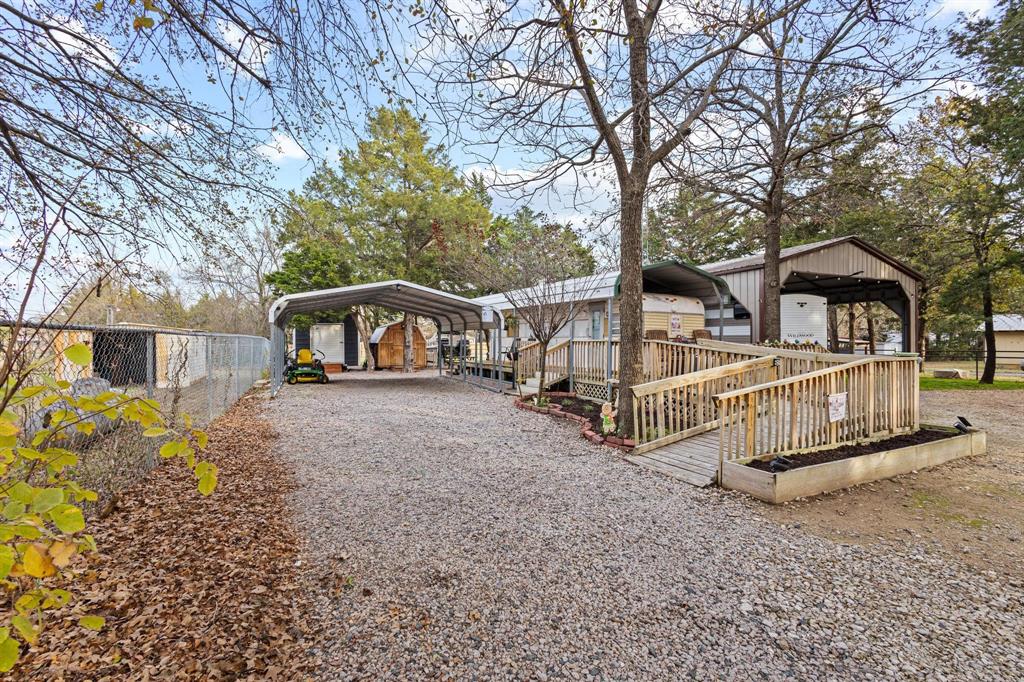 988 County Road Gordonville, TX 76245 - Photo 3 of 35 a view of a house with large trees and wooden fence