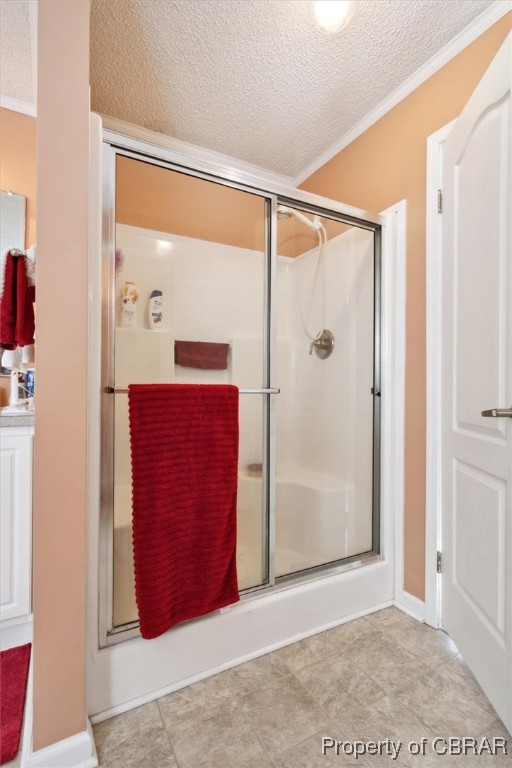 1413 Locust Grove Road Topping, VA 23169 - Photo 20 of 50 Bathroom featuring a textured ceiling, a shower with shower door, and crown molding