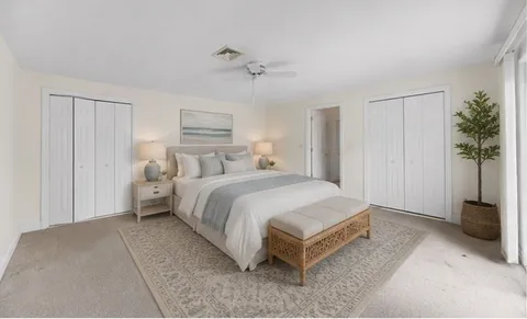 a spacious bedroom with a bed and a potted plant