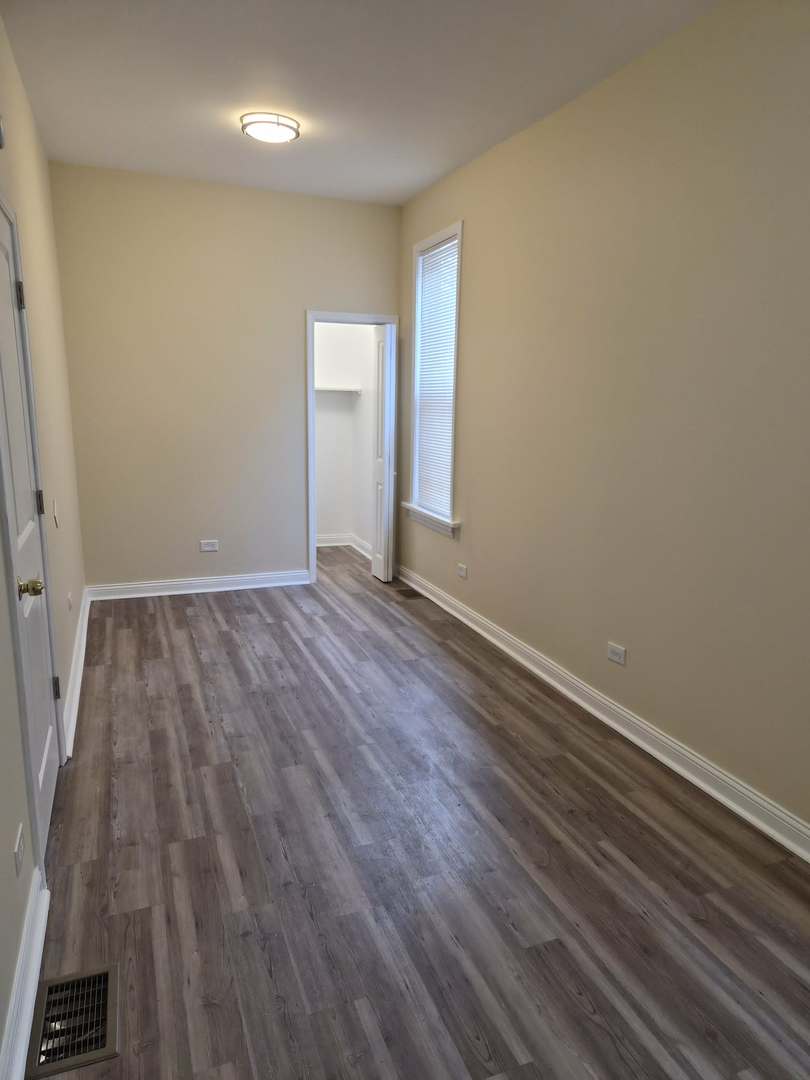 1234 West 72nd Street Chicago, IL 60636 - Photo 5 of 35 an empty room with wooden floor and windows