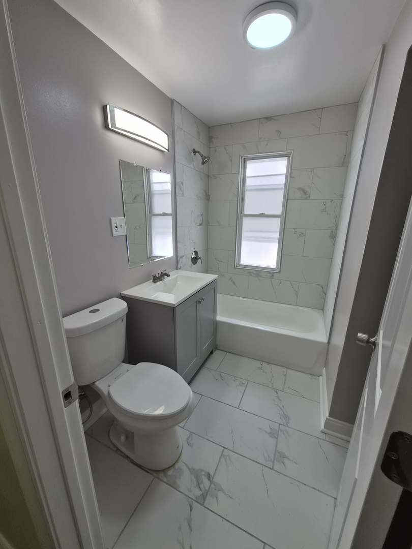 1234 West 72nd Street Chicago, IL 60636 - Photo 9 of 35 a bathroom with a toilet sink and mirror